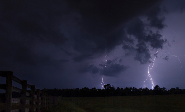 Lightning strike across a dark stormy sky.